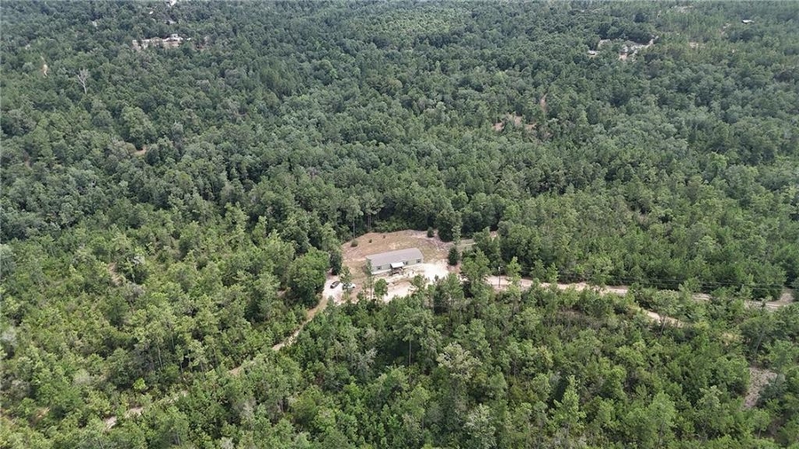 Aerial view of acreage property in the middle of wooded area